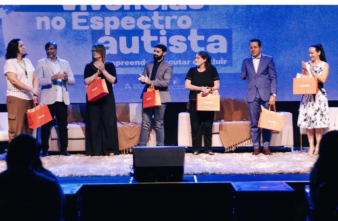 Palestrantes reunidos no palco do simpósio